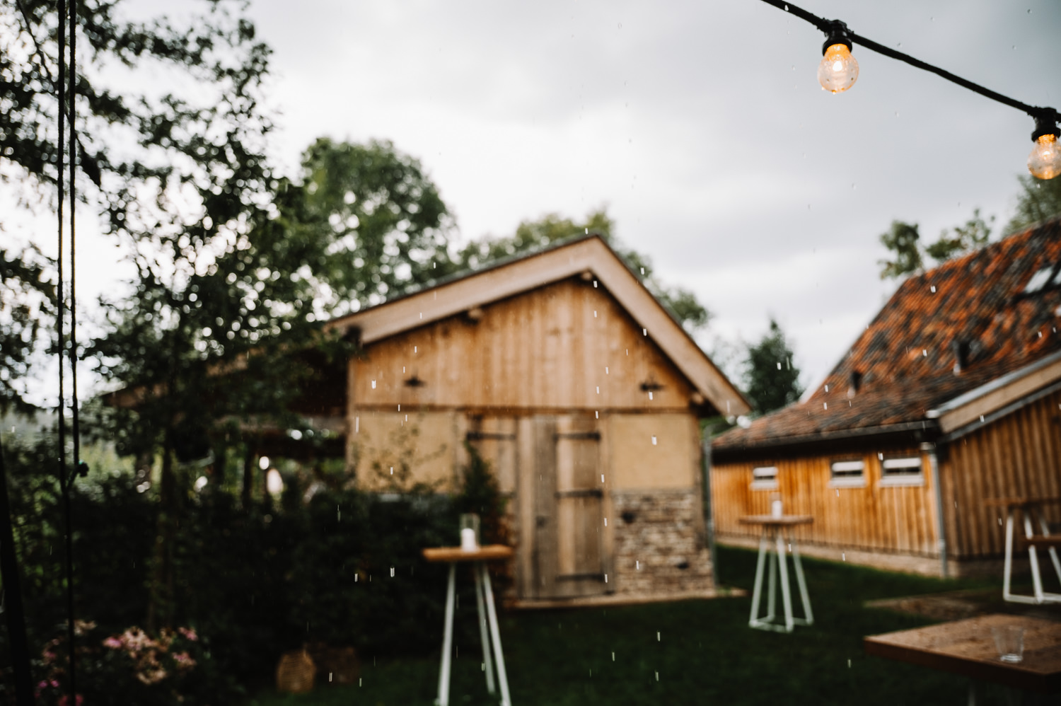Regen op de bruiloft bij Hoeve Hurpesch in Mechelen waar de statafels en prikverlichting zichtbaar zijn
