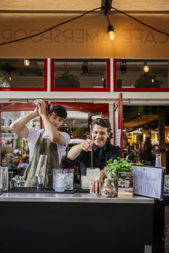 Barmannen staan achter de bar om cocktails te shaken