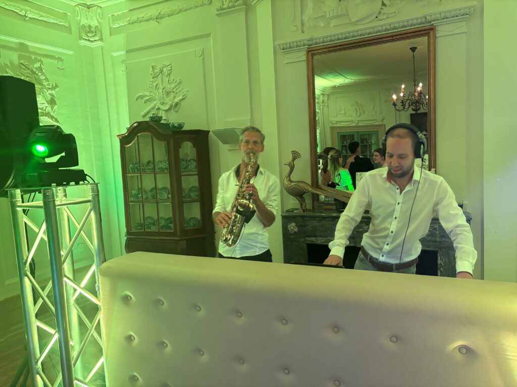 Combinatie tussen DJ en live muziek door Saxofonist in beeld