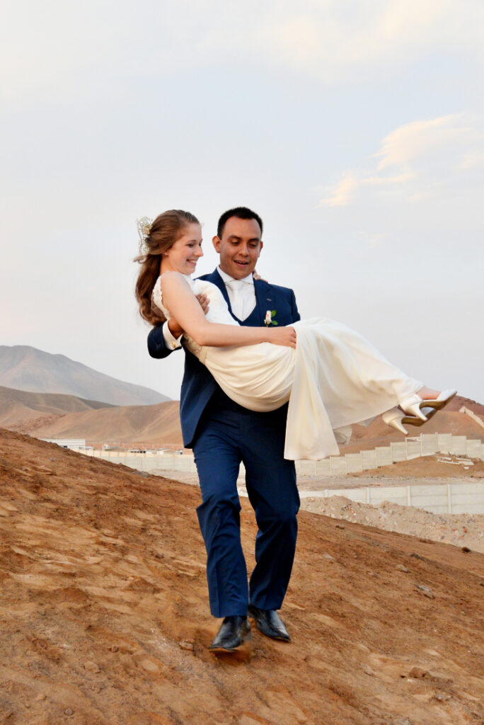 Bruidspaar in de natuur waarbij de bruidegom de bruid optilt