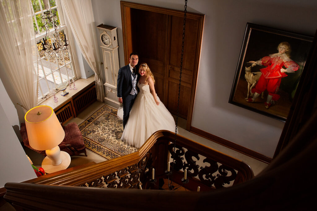Bruidspaar van bovenaf gefotografeerd in een trappenhuis