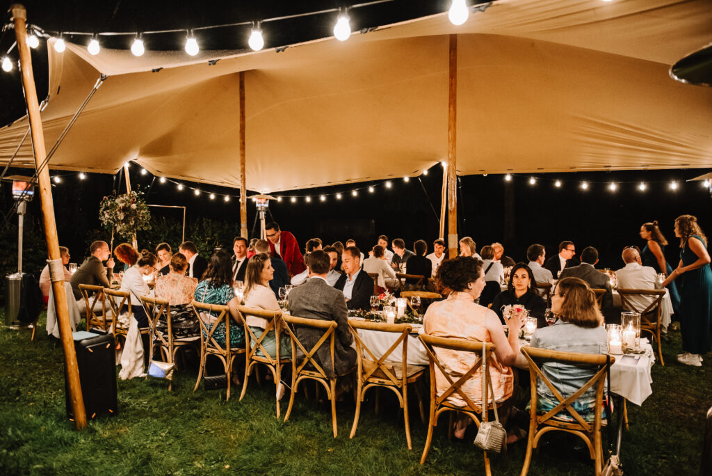 Dineren onder de stretchtent met prikverlichting tijdens een regenachtige avond