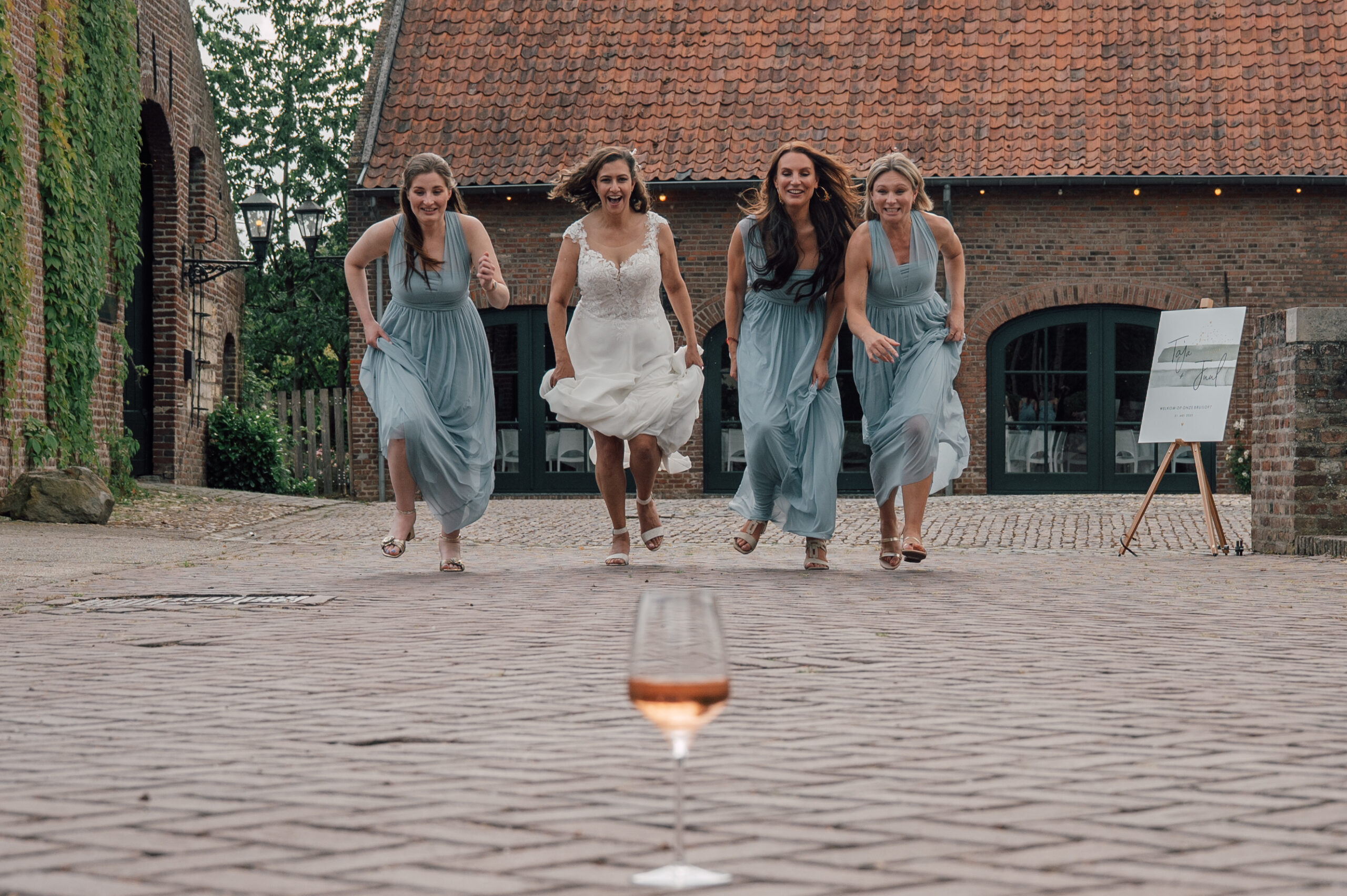 Bruid rent met bruidsmeisjes naar wijnglas