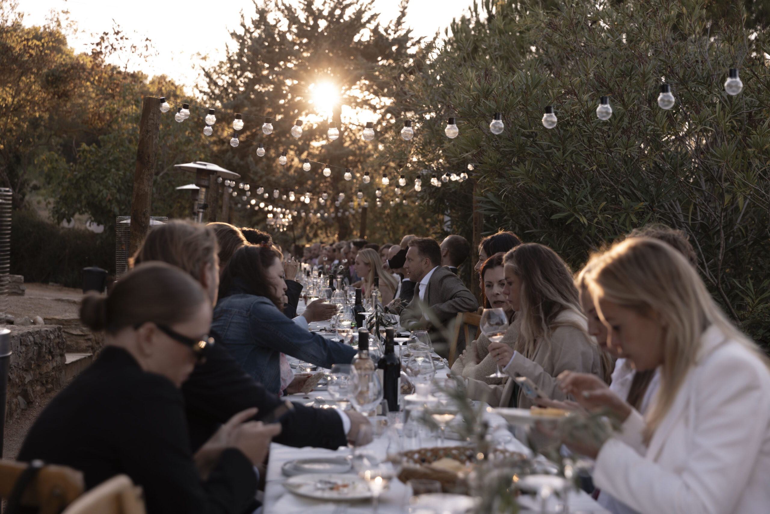 Diner met lampjes aan lange tafel in NOUS Zuid Frankrijk