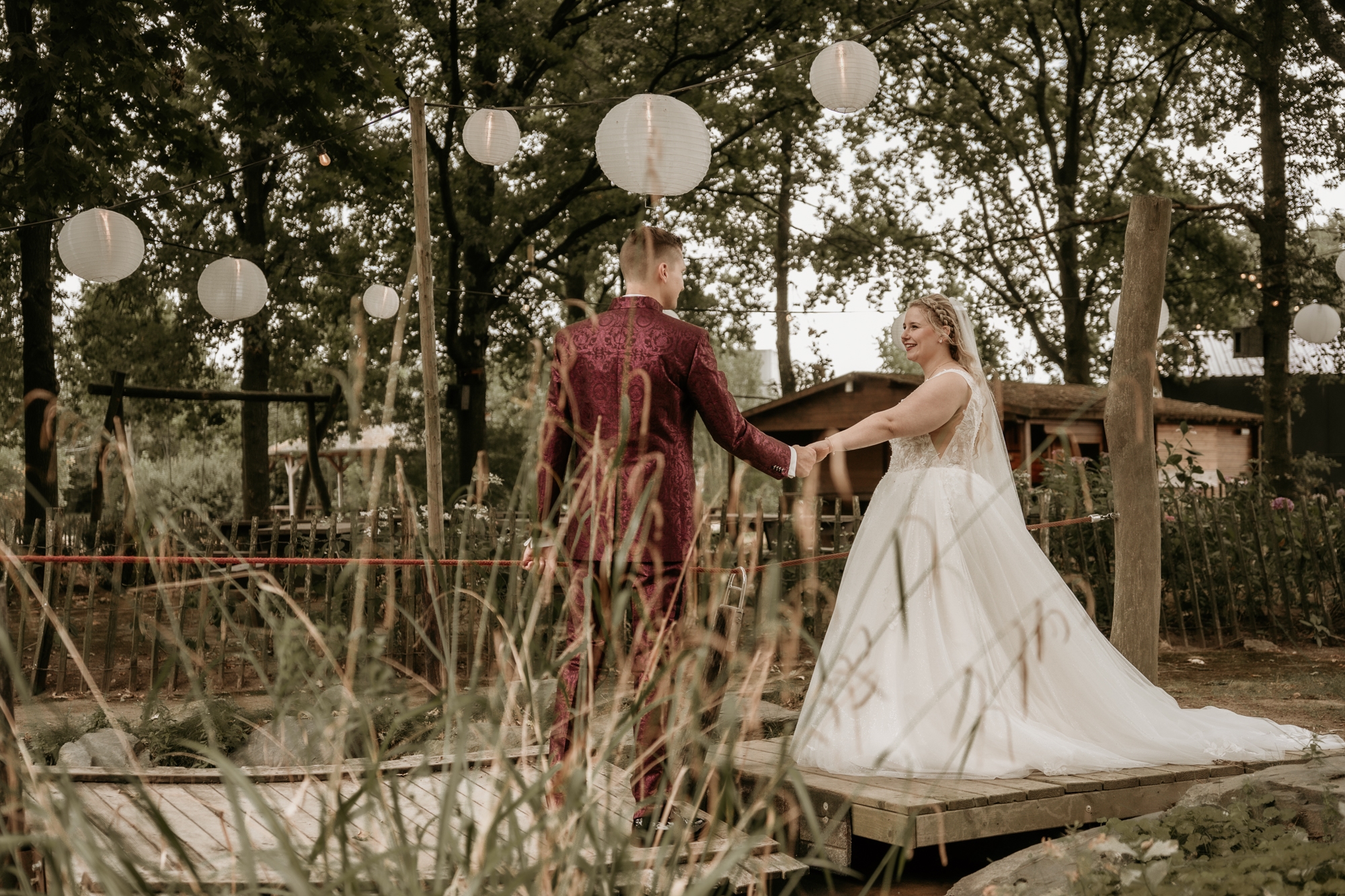 Bruidspaar in de natuur waarbij de bruid zich omdraait naar de camera