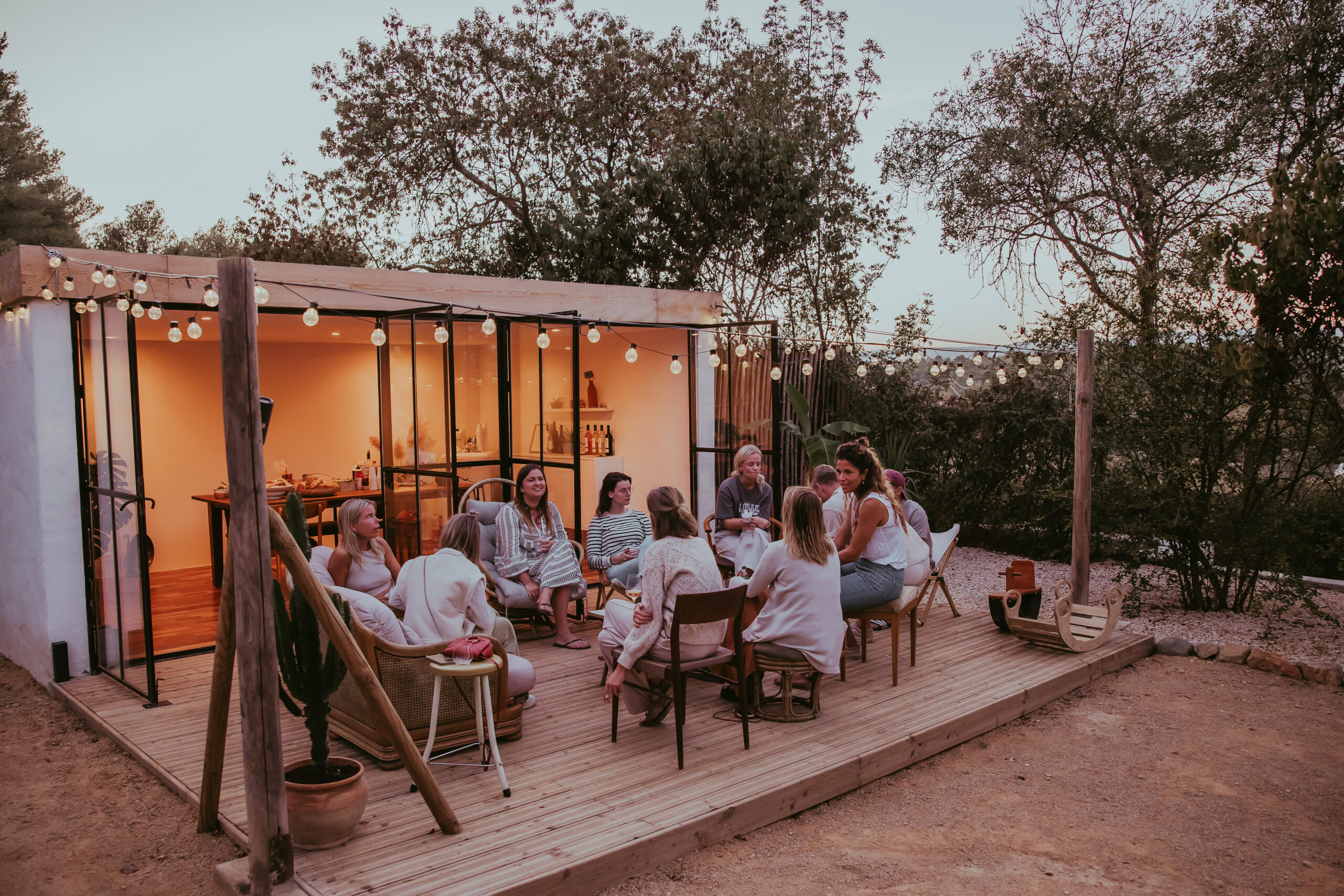 Gasten zitten gezellig bij elkaar voor de lofts bij NOUS Zuid Frankrijk