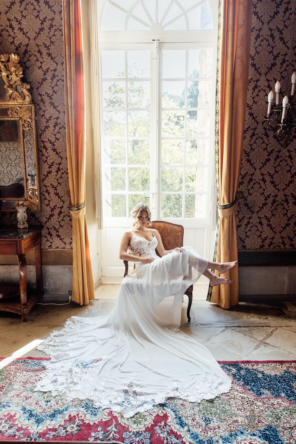 Bruid poseert op vintage stoel in kasteel Frankrijk