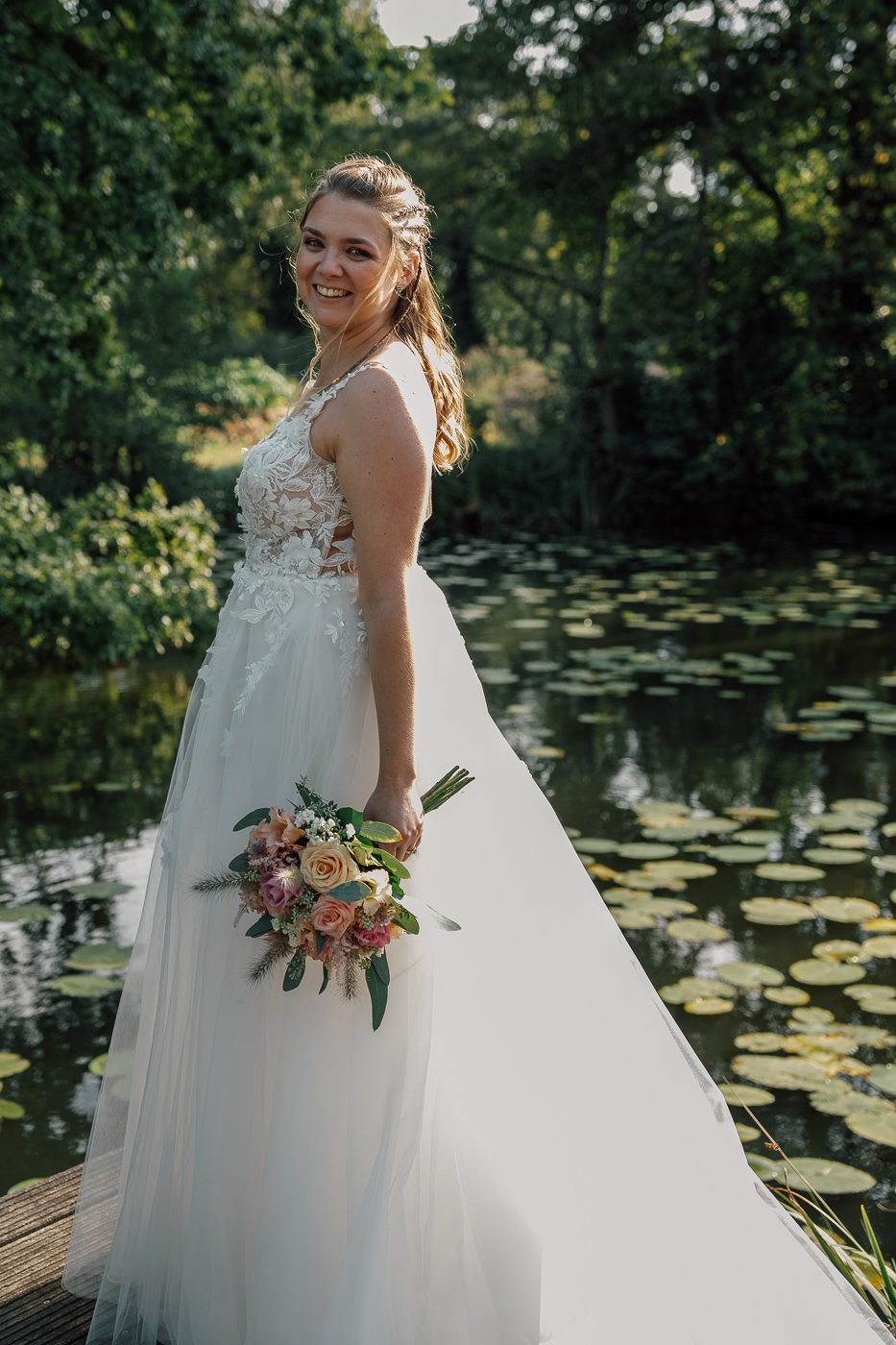 Bruid met bruidsboeket bij vijver kasteel