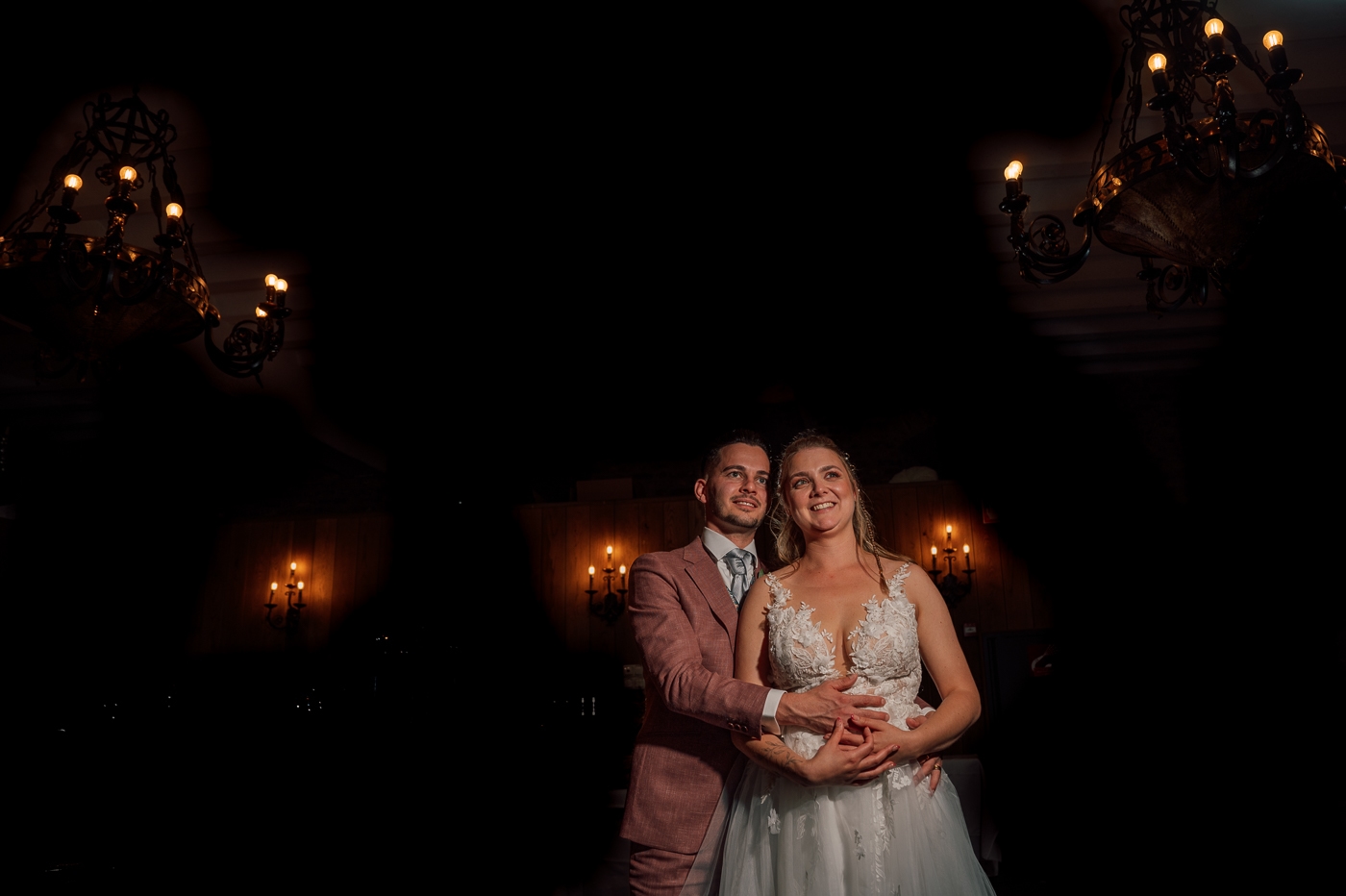 Foto van bruidspaar in de avond met romantische kaarsen in de achtergrond