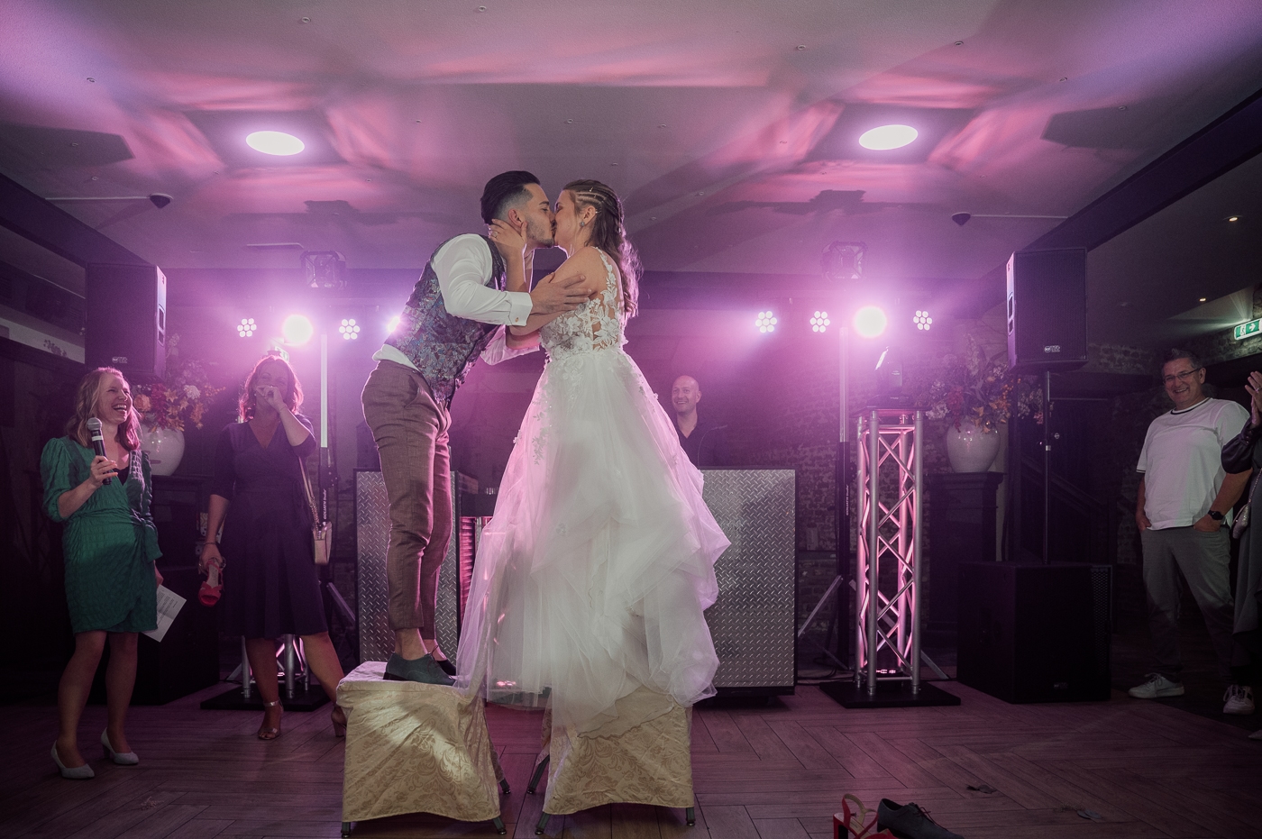 Bruidspaar voor DJ booth met roze lichten feest