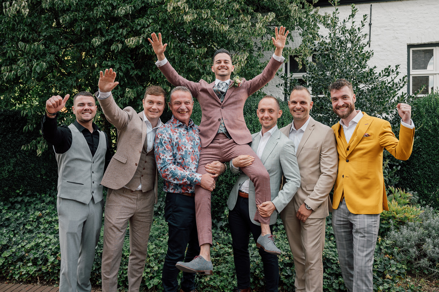 Mannen tillen bruidegom op als groepsfoto