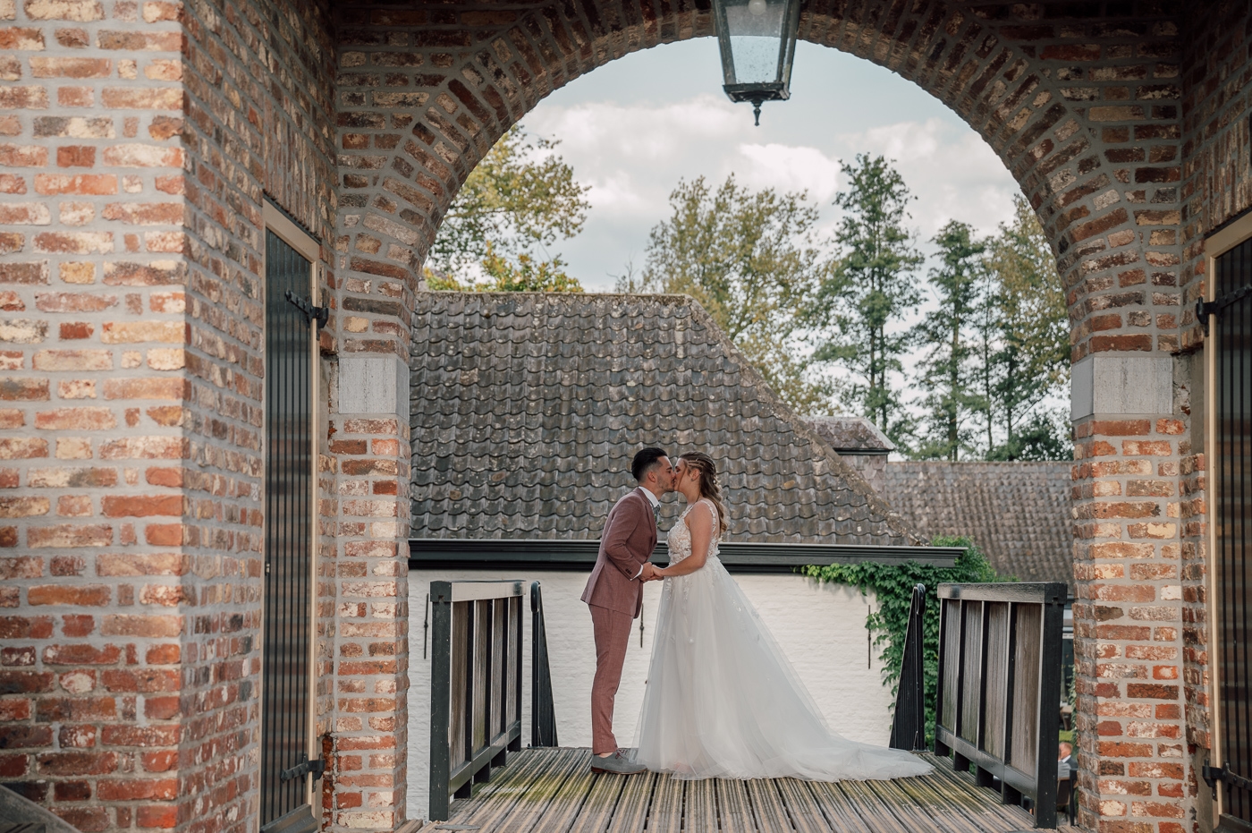 Bruidspaar onder ronde poort bij Kasteel