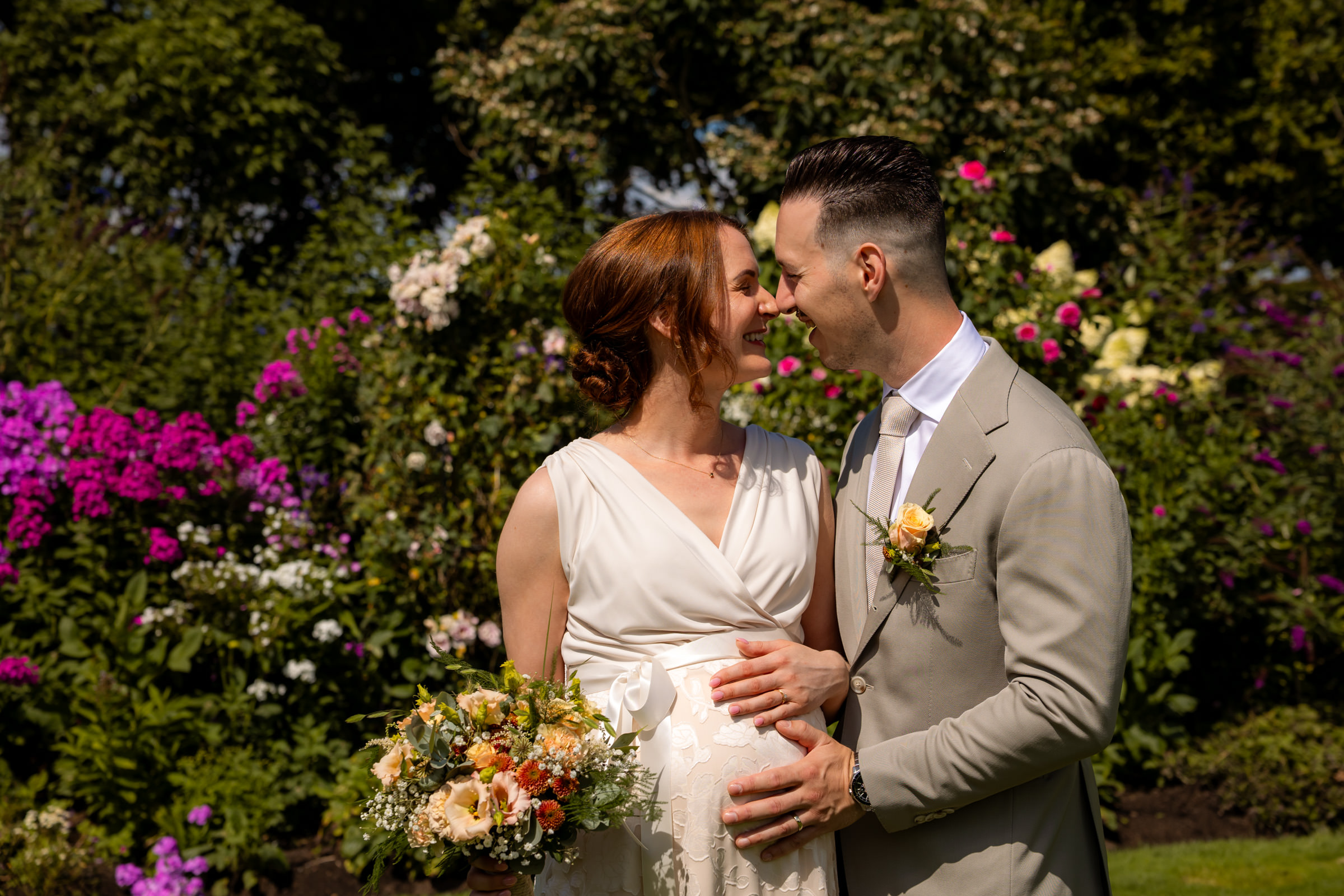 Zwangere bruid tijdens fotoshoot in trouwjurk