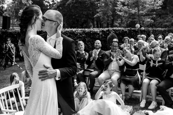 Bruidspaar in zwart-wit tijdens ceremonie kussend