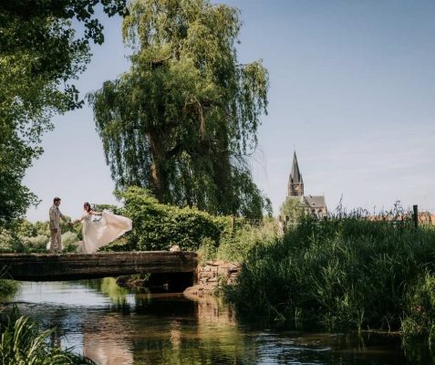 Bruidspaar Thorn op bruggetje met witte kerk op de achtergrond