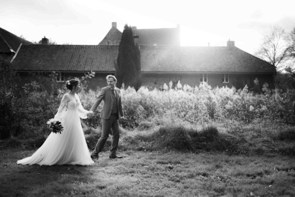 Bruidspaar voor een hoeve in zwart wit