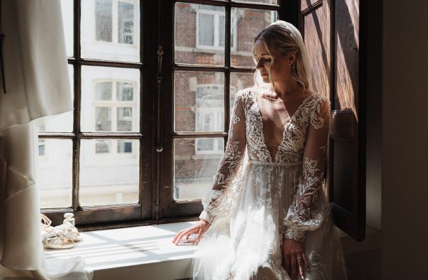Bruid in bruidsjurk bij een mooi raam