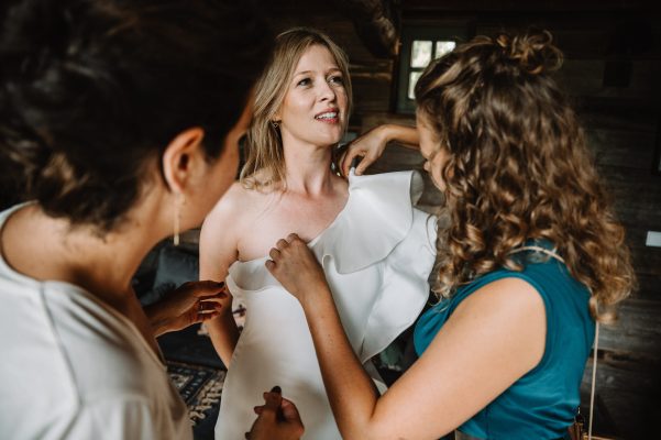 Ceremoniemeester FBLS Weddings helpt met bruid aankleden in trouwjurk