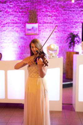 Violiste in feestzaal met DJ