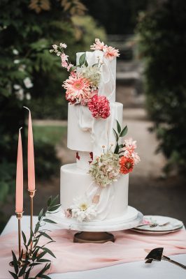 Witte bruidstaart met gekleurde bloemen