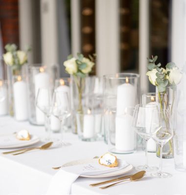 Dinerstyling bruiloft chique met kaarsen in windlichten en gouden bestek