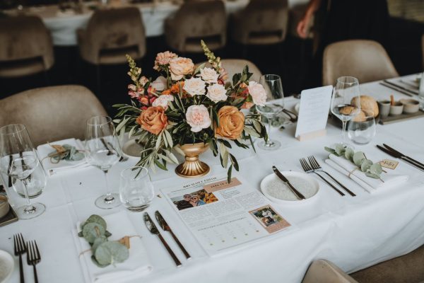 Simpele dinertafel bruiloft met bloemstuk op verhoging