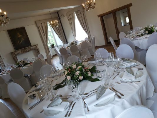 Ronde diner tafels ingedekt met witte servetten en bloemen