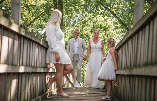 Bruidspaar met gast en bruidsmeisje op brug