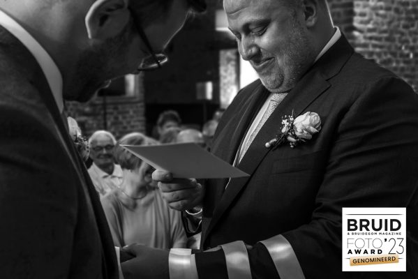 Bruidegom leest geloften bij ceremonie op zwart wit foto