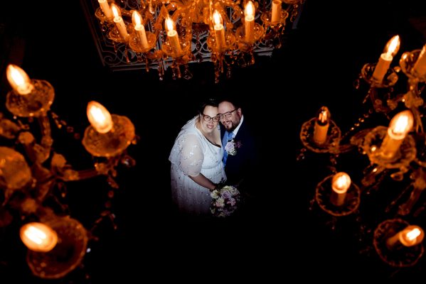 Trouwfoto in kasteel met kandelaren en bruidspaar