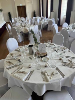 Huwelijksdiner met ronde tafels en wit linnen met witte stoelhoezen