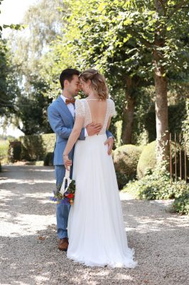 Bruidspaar poseert smen in groene omgeving