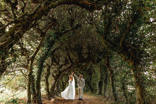 Bruidspaar tussen het groen in boomgaard