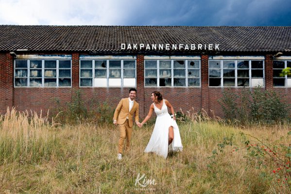 Bruidspaar in het gras voor de pannenfabriek in Limburg
