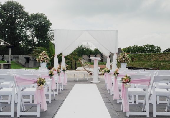 Ceremonie bruiloft met witte loper en witte bruiloft klapstoelen