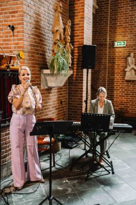 Zangeres in lichte kleding met key board