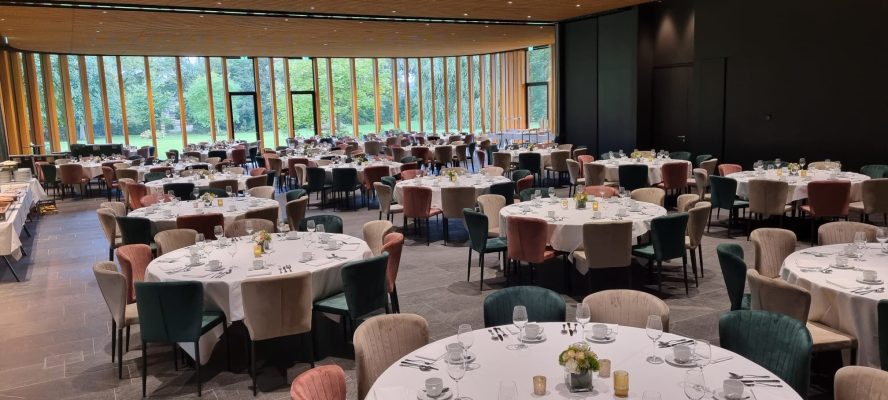 Verschillende kleuren stoelen aan ronde tafels in Paviljoen Chateau St. Gerlach