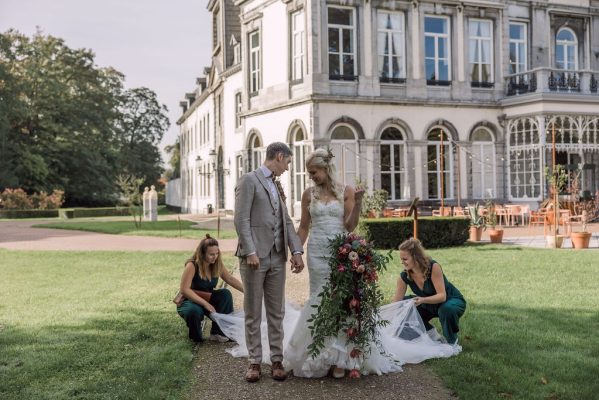 Ceremoniemeesters FBLS Weddings leggen jurk goed bij fotoshoot bruidspaar voor Kasteel Vaeshartelt in Maastricht