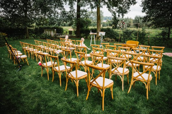 Ceremonie met crossback stoelen in hout in tuin vakantiewoning