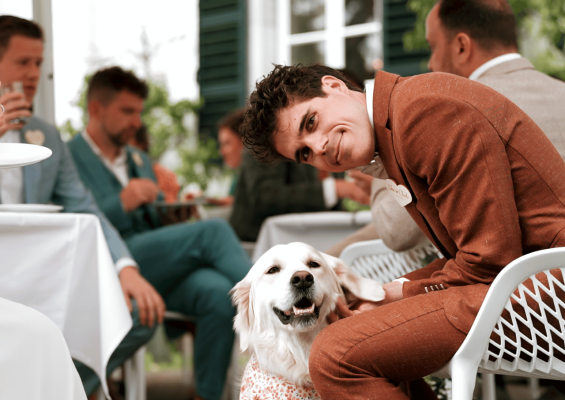 Trouwfilm bij huwelijksceremonie waar de hond zichtbaar is met een van de gasten