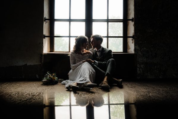 Videografie shot met bruidspaar voor ramen