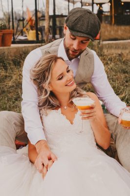 Bruidspaar bij hooibalen met drankje in de hand