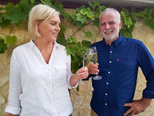 Eigenaren van Wijngoed Fromberg proosten met een glas eigen wijn