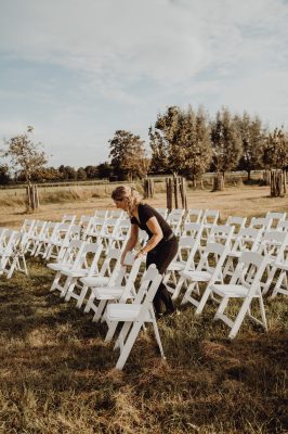 Ceremoniemeester zet stoelen in juiste opstelling voor ceremonie